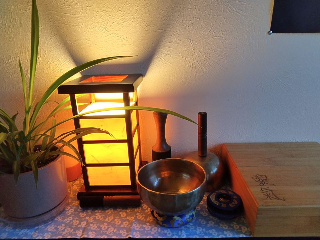 Warm shoji lantern with a singing bowl and plants in the healing space